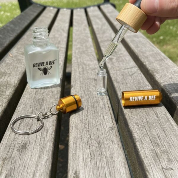 bee revival kit refill bottle being use on a park bench to refill a gold rescue keyring